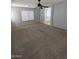 Spacious primary bedroom featuring carpet, ceiling fan, and natural light at 15446 W Jenan Dr, Surprise, AZ 85379