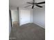 Neutral toned bedroom with gray carpet, closet, ceiling fan and neutral paint at 15446 W Jenan Dr, Surprise, AZ 85379