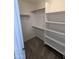 A spacious walk-in closet featuring shelving and wooden rods at 15446 W Jenan Dr, Surprise, AZ 85379