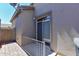 A small back porch with a railing, and sliding door to the interior, and stone flooring at 15806 N 107Th Pl, Scottsdale, AZ 85255