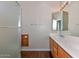 Bathroom with double sinks, light wood cabinetry, and walk-in shower at 15806 N 107Th Pl, Scottsdale, AZ 85255