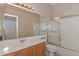 Traditional bathroom with a light wood vanity, large mirror, and a tub/shower combo at 15806 N 107Th Pl, Scottsdale, AZ 85255