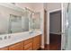 Bathroom featuring double sinks, wood cabinets, and a walk-in shower at 15806 N 107Th Pl, Scottsdale, AZ 85255