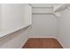 Spacious walk-in closet with wood floor, white walls, shelving, and closet rod at 15806 N 107Th Pl, Scottsdale, AZ 85255