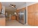 Well-lit kitchen with stainless steel refrigerator, wooden cabinets, and tan backsplash at 15806 N 107Th Pl, Scottsdale, AZ 85255