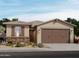 Charming single-story home with a stone accent and a two-car garage at 16014 W Desert Hollow Dr, Surprise, AZ 85387