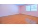 Bedroom with laminate flooring, a ceiling fan and light walls, as well as a window at 1726 W Claremont St, Phoenix, AZ 85015