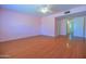 Spacious bedroom with ceiling fan, laminate floors, neutral color, and a view into the hallway at 1726 W Claremont St, Phoenix, AZ 85015