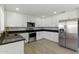 Modern kitchen featuring white cabinets, black countertops, and stainless steel appliances with wood-style flooring at 1741 S Clearview Ave # 74, Mesa, AZ 85209