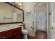 Bathroom with a wooden vanity, decorative mirror, and access to the shower at 21614 N 59Th Ln, Glendale, AZ 85308