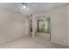 Neutral carpeted bedroom features ceiling fan, mirrored closet, and adjacent bathroom at 21614 N 59Th Ln, Glendale, AZ 85308