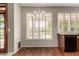 Dining area with modern chandelier, wooden floors, and window views of outdoor pool at 21614 N 59Th Ln, Glendale, AZ 85308