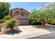 Inviting home with a two-car garage, complemented by lush greenery and mature landscaping for enhanced curb appeal at 21614 N 59Th Ln, Glendale, AZ 85308