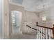 Bright upstairs hallway with neutral walls, plush carpet and decorative white wood banister at 21614 N 59Th Ln, Glendale, AZ 85308