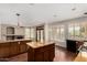 Spacious kitchen featuring wood cabinets, a center island with stone countertops and stainless steel appliances at 21614 N 59Th Ln, Glendale, AZ 85308