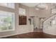Elegant living room boasting hardwood floors, plantation shutters, and a dramatic staircase creating a welcoming atmosphere at 21614 N 59Th Ln, Glendale, AZ 85308