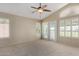 Serene main bedroom with a ceiling fan and natural light from multiple windows and a private balcony at 21614 N 59Th Ln, Glendale, AZ 85308