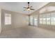 Serene main bedroom with a vaulted ceiling, ceiling fan and natural light from multiple windows and a private balcony at 21614 N 59Th Ln, Glendale, AZ 85308