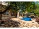 Covered patio with stone tile, showcasing the beautiful pool area and landscaping, ideal for outdoor living at 21614 N 59Th Ln, Glendale, AZ 85308