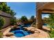 Backyard pool features a rock waterfall and tropical foliage and a stone tile surround at 21614 N 59Th Ln, Glendale, AZ 85308