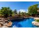 Sparkling pool with a stone waterfall feature and lush tropical landscaping creates a backyard paradise at 21614 N 59Th Ln, Glendale, AZ 85308