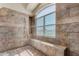 Tiled walk-in shower with seating bench and a window offering natural light at 21614 N 59Th Ln, Glendale, AZ 85308