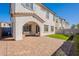Spacious backyard featuring a covered patio, brick pavers, green lawn, and privacy wall for outdoor living at 2195 N Peden Dr, Chandler, AZ 85225