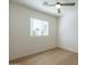 Bright bedroom with a modern ceiling fan, light wood floor, and large window at 2195 N Peden Dr, Chandler, AZ 85225