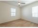 Sunlit bedroom with a modern ceiling fan and two windows at 2195 N Peden Dr, Chandler, AZ 85225