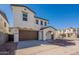 Charming two-story home featuring a brown two-car garage door, arched entrance, and well-maintained landscaping at 2195 N Peden Dr, Chandler, AZ 85225
