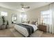 Bright main bedroom featuring a comfortable bed, a ceiling fan, and hardwood floors at 2195 N Peden Dr, Chandler, AZ 85225