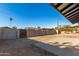 Spacious backyard, enclosed by a cinderblock wall and wooden gate, ready for landscaping at 2242 W Pecan Rd, Phoenix, AZ 85041