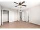 Spacious bedroom with tiled flooring, ceiling fan, and closet space for storage at 2242 W Pecan Rd, Phoenix, AZ 85041