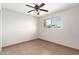 Bright bedroom featuring neutral walls, tile flooring, a ceiling fan, and a window with neighborhood views at 2242 W Pecan Rd, Phoenix, AZ 85041