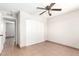 This bedroom is finished with tile flooring, a ceiling fan, and a closet; a door leads to another room at 2242 W Pecan Rd, Phoenix, AZ 85041
