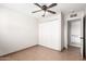 This bedroom has tile flooring, a ceiling fan, and a closet for storage; a doorway leads to another room at 2242 W Pecan Rd, Phoenix, AZ 85041