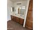 The bathroom includes a double sink vanity with wood cabinets and a large mirror at 22872 W Gardenia Dr, Buckeye, AZ 85326