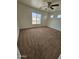 This bright bedroom features plush carpeting, a ceiling fan and a window with a view at 22872 W Gardenia Dr, Buckeye, AZ 85326