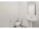 Powder room featuring a pedestal sink, standard toilet, and gray tile floor at 24486 W Grenadine Rd, Buckeye, AZ 85326