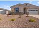 Tan single story home featuring colorful flowers, neutral landscaping, and an attached two-car garage at 24486 W Grenadine Rd, Buckeye, AZ 85326