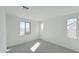 Minimalist-style bedroom with neutral carpeting, three windows and bright natural light at 25130 N 156Th Ln, Surprise, AZ 85387