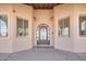 Covered entryway featuring a wrought iron door with glass inset and sconces flanking either side at 2731 W Desert Ranch Rd, Phoenix, AZ 85086
