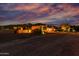 Inviting desert home with warm lighting, mature trees, and stunning mountain views at dusk at 2731 W Desert Ranch Rd, Phoenix, AZ 85086