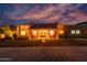 Front exterior of a desert home at dusk with desert landscaping, a covered porch, and front-facing windows at 2731 W Desert Ranch Rd, Phoenix, AZ 85086
