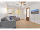 Cozy living room with a comfortable sectional sofa, mounted TV, and windows for natural light at 2731 W Desert Ranch Rd, Phoenix, AZ 85086