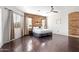 Spacious primary bedroom with wood-paneled wall, ceiling fan, and a view to the outside at 2731 W Desert Ranch Rd, Phoenix, AZ 85086