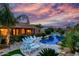 Private backyard oasis with pool, lush greenery, and poolside seating at dusk at 2731 W Desert Ranch Rd, Phoenix, AZ 85086