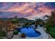 Gorgeous backyard pool with rock features, lush landscaping, and scenic mountain views at 2731 W Desert Ranch Rd, Phoenix, AZ 85086