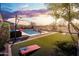 Inviting backyard with artificial turf, a sparkling pool, and comfortable seating, perfect for relaxation and outdoor enjoyment at 31046 N 138Th Ave, Peoria, AZ 85383