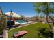 Lush backyard featuring a swimming pool, artificial turf, and recreational game areas for outdoor fun at 31046 N 138Th Ave, Peoria, AZ 85383